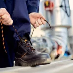 man tying shoelace of his Caterpillar Safety Shoes