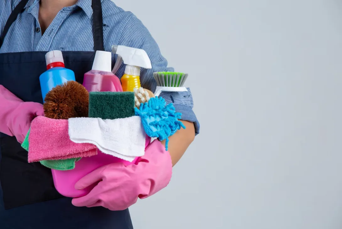 Indonesia maid holding a bunch of essential cleaning tools