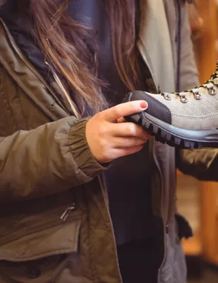 woman holding Puma Safety Shoes for further inspection