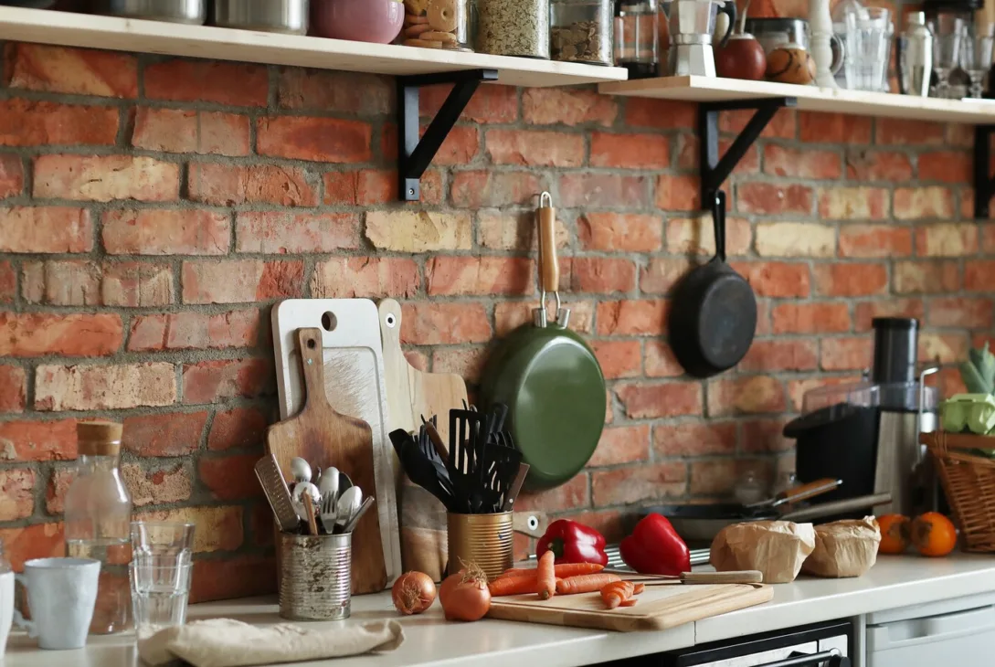 a kitchen counter with kitchen appliances such as stainless steel utensils