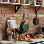 a kitchen counter with kitchen appliances such as stainless steel utensils