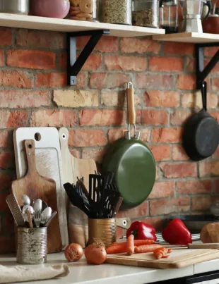 a kitchen counter with kitchen appliances such as stainless steel utensils