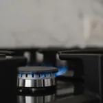 close-up of a gas burner with blue flame on a stove