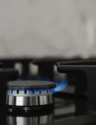 close-up of a gas burner with blue flame on a stove