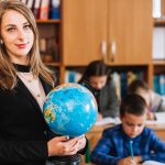 a teacher holding a globe in an international school