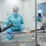 a pharmacist observing supplement pills in a food manufacturing company