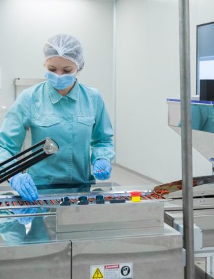 a pharmacist observing supplement pills in a food manufacturing company