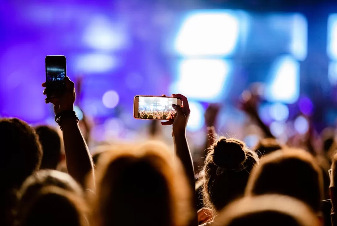 attendees taking photographs of performances in an event hosted by event management company