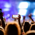 attendees taking photographs of performances in an event hosted by event management company