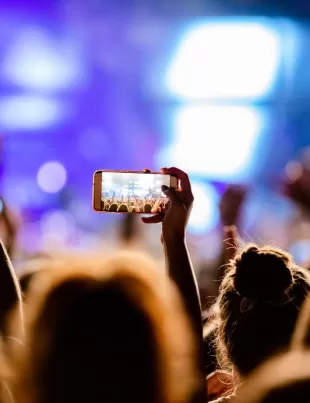 attendees taking photographs of performances in an event hosted by event management company