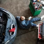 top view of man performing luxury car maintenance at workshop in Shah Alam