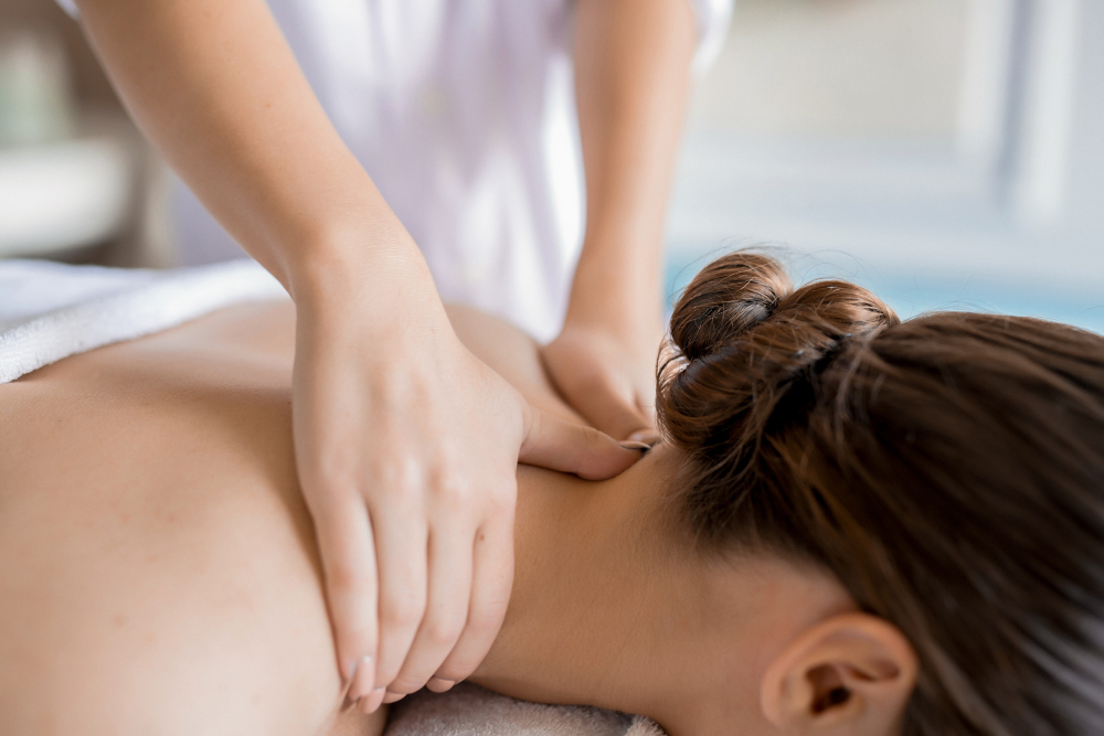 a woman giving her customer a back therapy massage