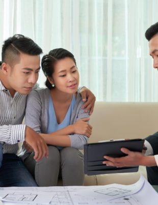 A construction consultant with his clients reviewing documents