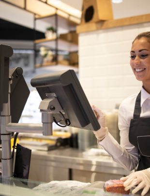 A girl infront of a cashier counter in a shop