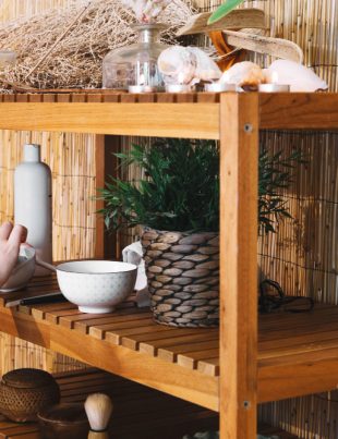 a woman rearranging things on her wooden display rack