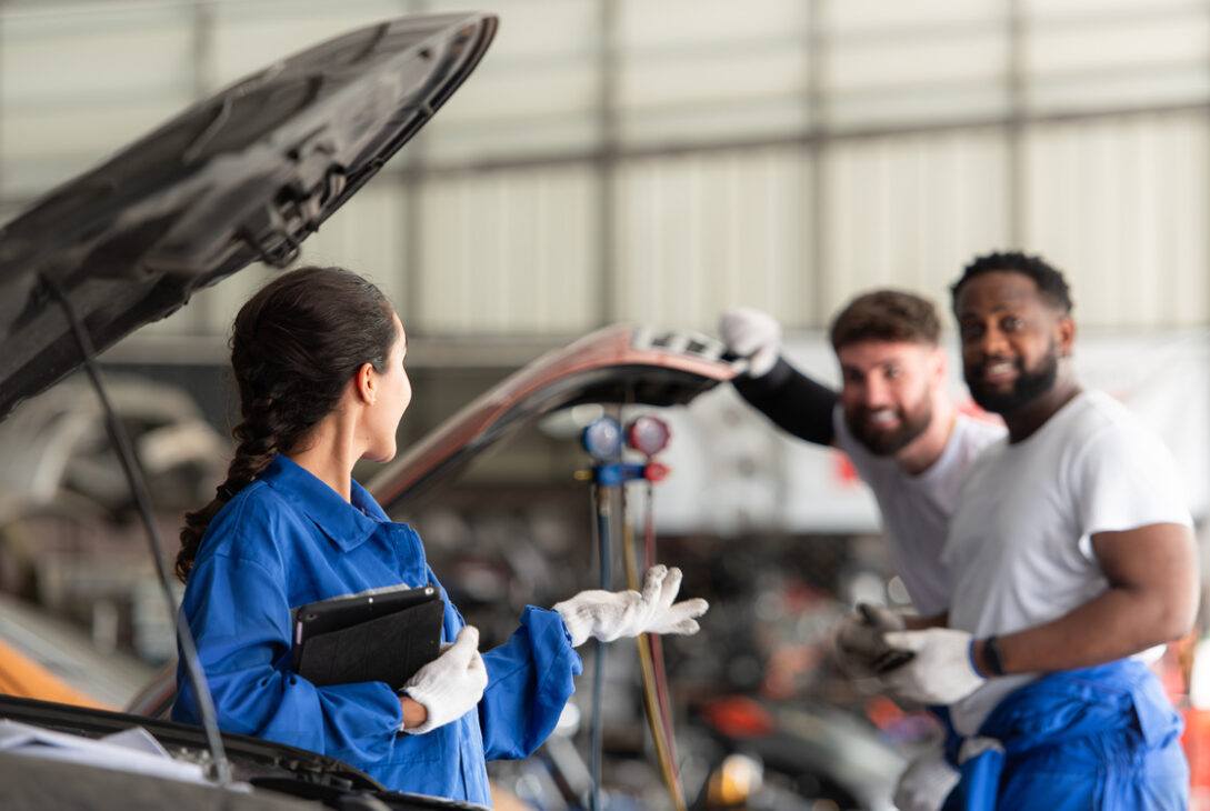 Professionals mechanics discussing on efficient solutions for Toyota car battery replacements.