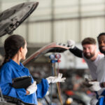 Professionals mechanics discussing on efficient solutions for Toyota car battery replacements.