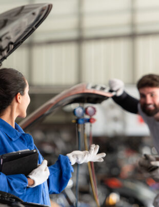 Professionals mechanics discussing on efficient solutions for Toyota car battery replacements.