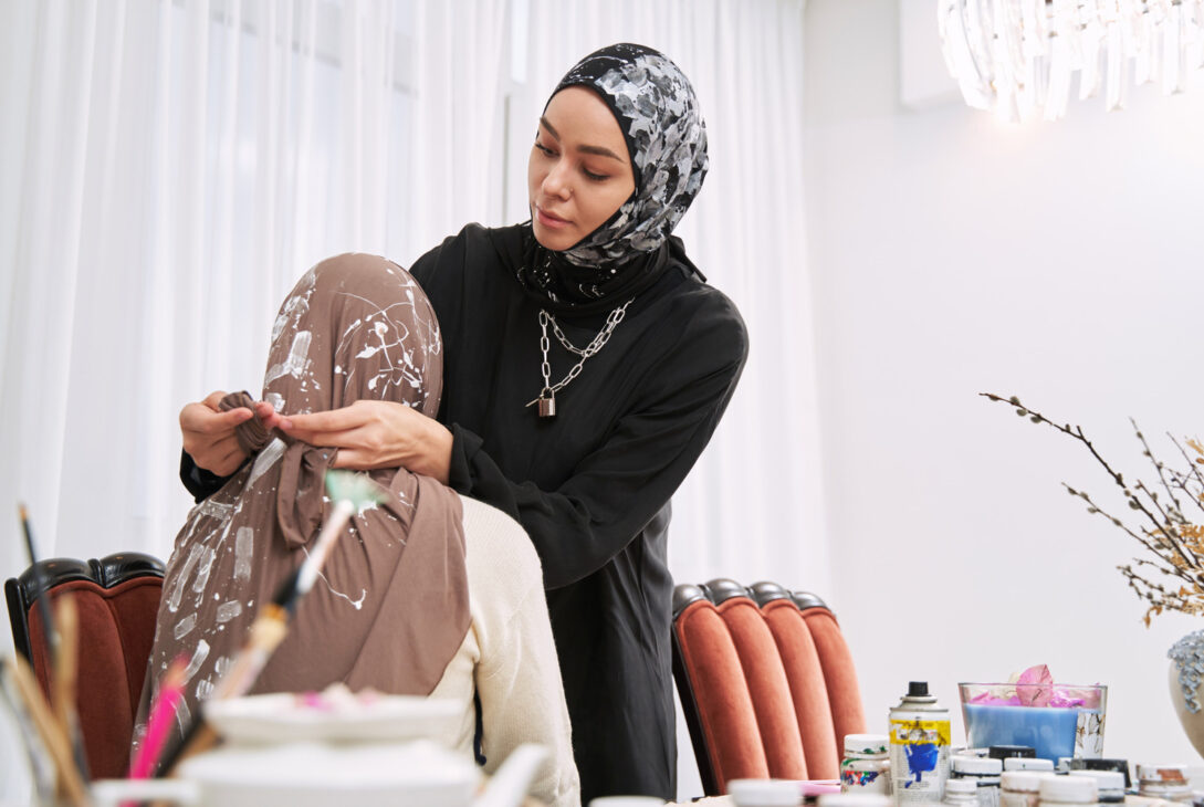 A stylist demonstrating the best shawl to style for the perfect Raya look.