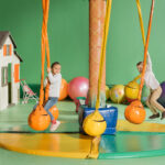 The two little children playing swings happily