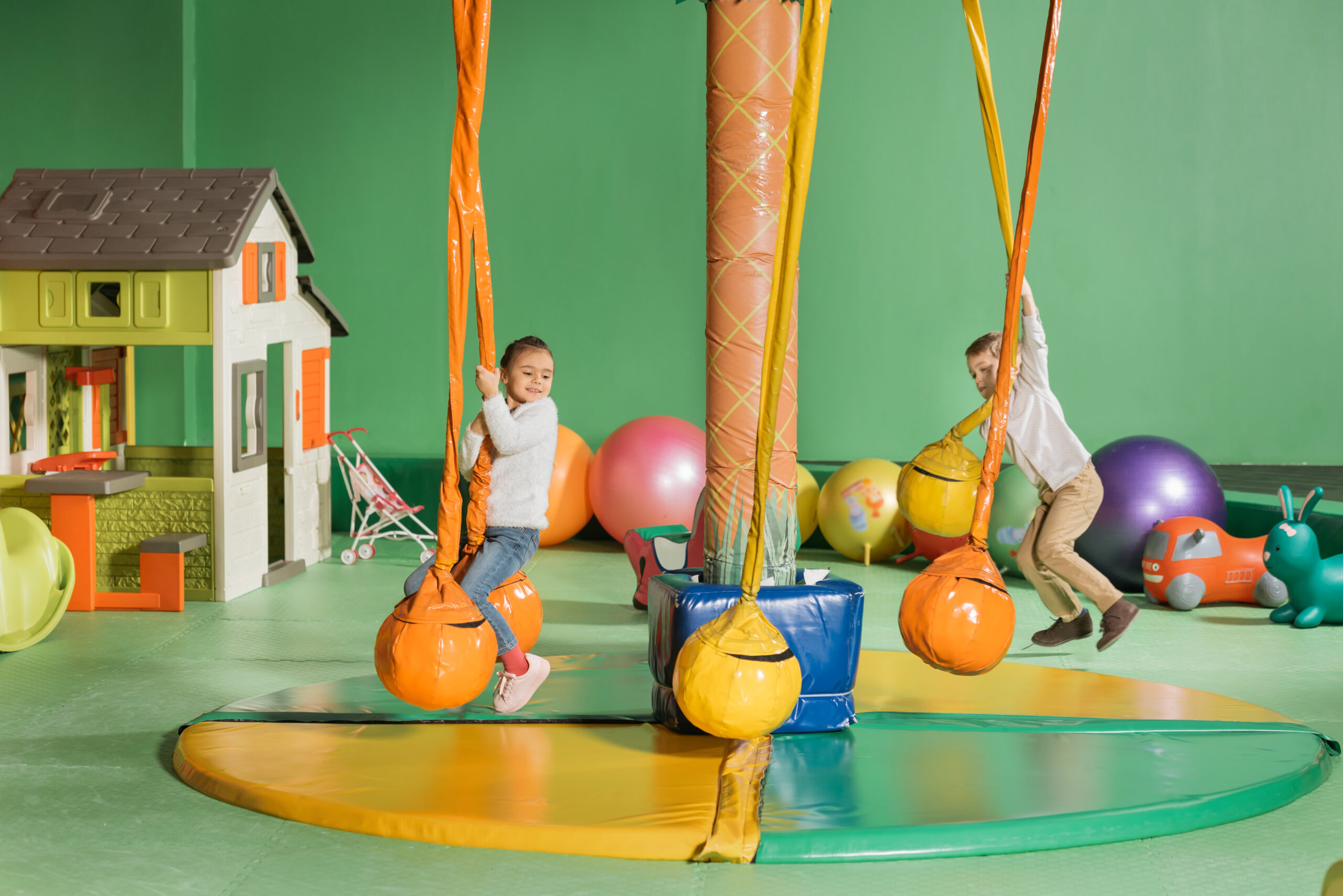 The two little children playing swings happily