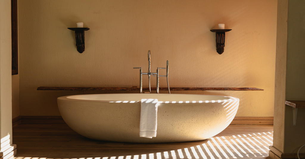 An exquisitely crafted standalone bath tub set against a neutral background.