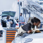 A professional mechanic expertly replacing a BMW car battery in a workshop.