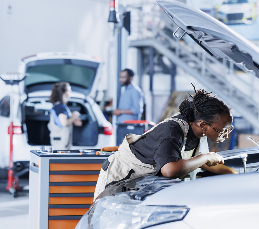 A professional mechanic expertly replacing a BMW car battery in a workshop.