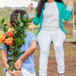 A boy discreetly hiding a beautiful flower bouquet to surprise his mom for Mother's Day.