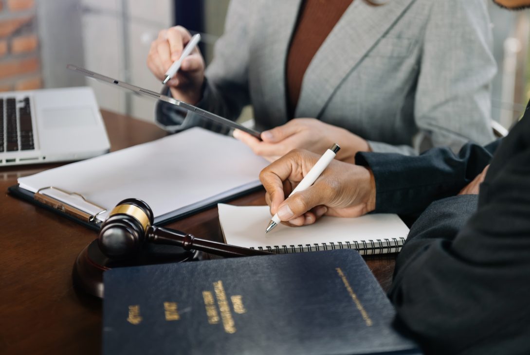 An expert lawyer is signing the document in legal firm.