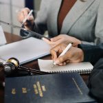 An expert lawyer is signing the document in legal firm.