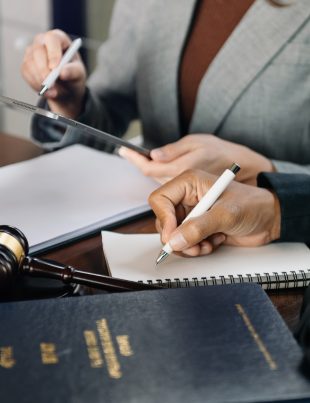 An expert lawyer is signing the document in legal firm.