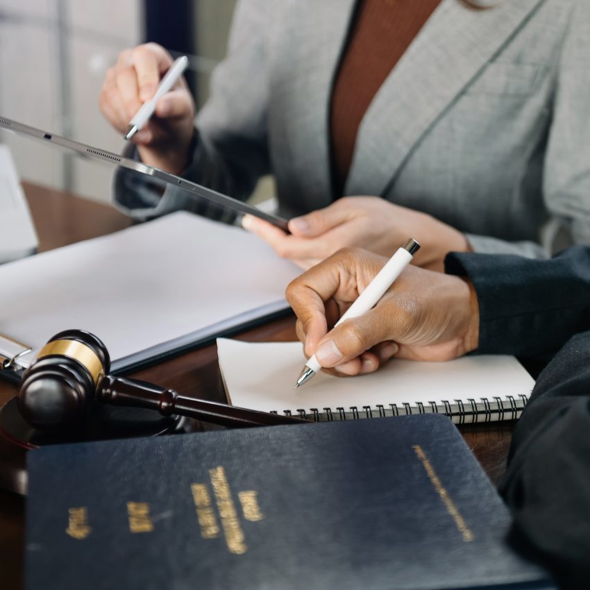 An expert lawyer is signing the document in legal firm.