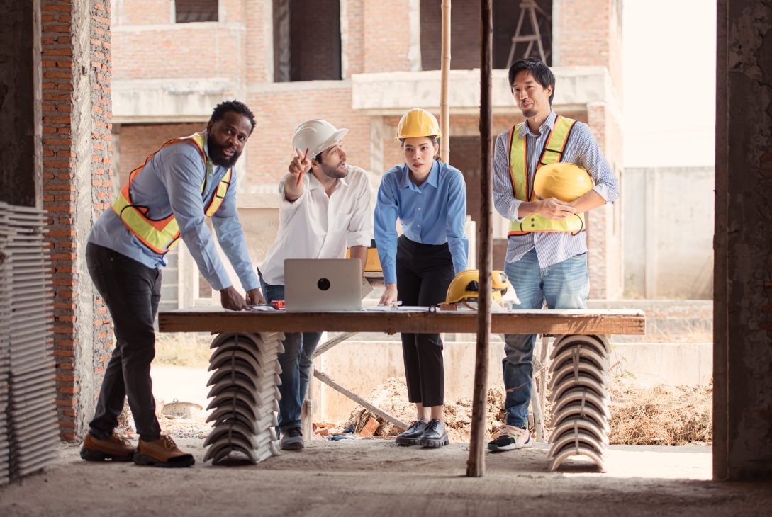 A group of workers discuss how to enhance the worksite needs for cabins and smart updates.