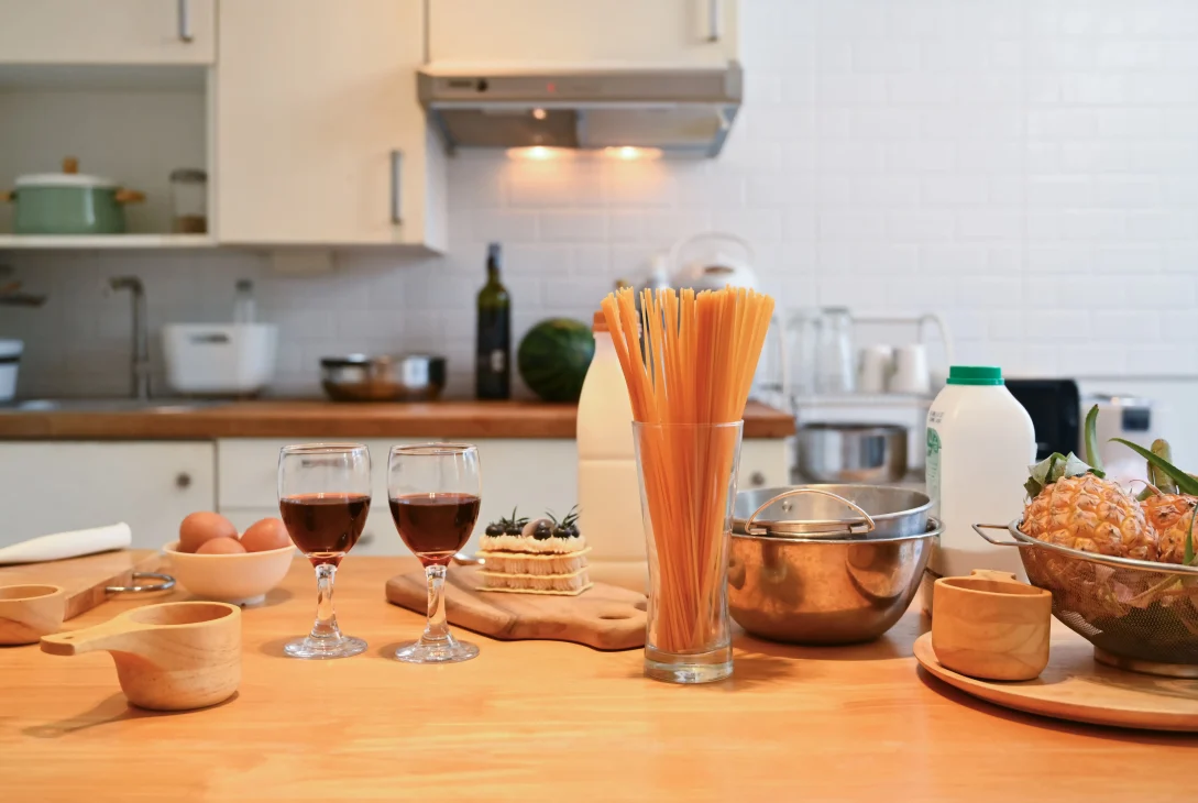 Cozy kitchen scene with glassware and cooking utensils on a wooden countertop.