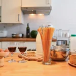 Cozy kitchen scene with glassware and cooking utensils on a wooden countertop.