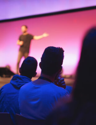 Audience watching a keynote speaker present on stage at a conference in Singapore